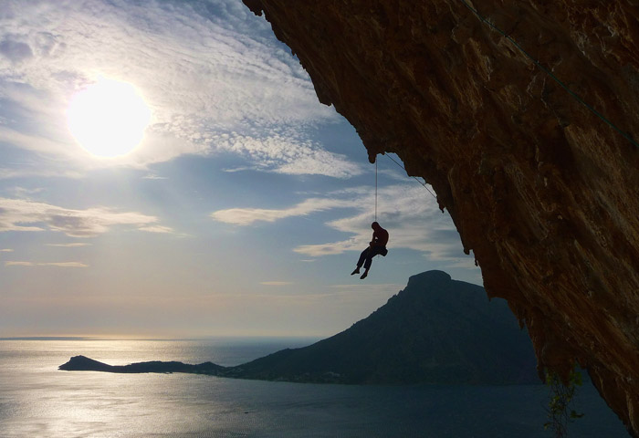 panoramica con climber appeso alla corda a picco sul mare dell'isola di kalymnos