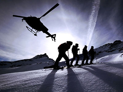 Heliski foto sciatori controluce mentre l'elicottero decolla