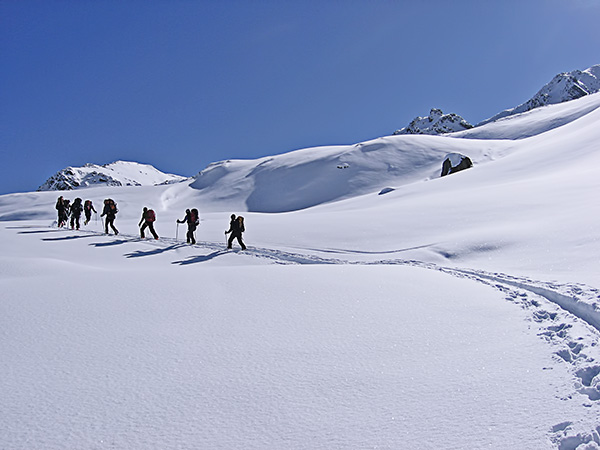 foto di scialpinisti che avanzano in progressione sul manto nevoso